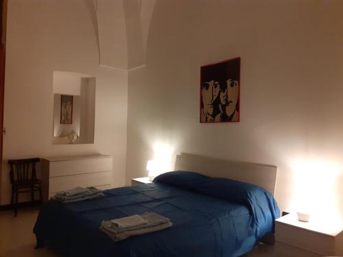 ein Schlafzimmer mit einem blauen Bett und zwei Lampen in der Unterkunft HAPPY HOUSE Salento Apartment in Brindisi