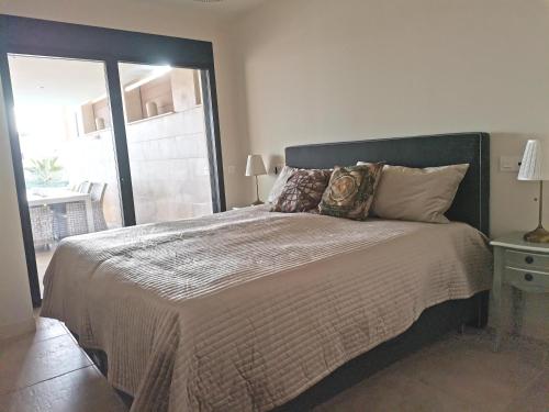 a bedroom with a large bed with a window at Holiday Apartment Azalea La Cala in La Cala de Mijas