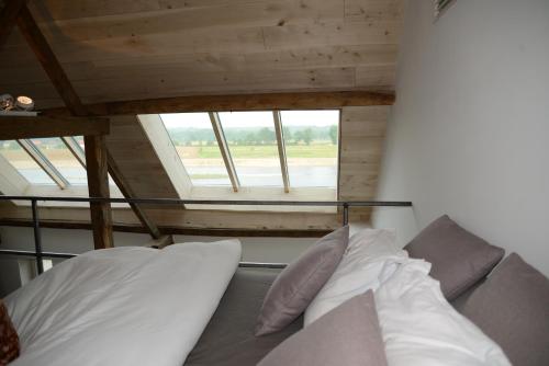 a bed with white pillows in a room with a window at Holiday Home Janssen & Janssen in Maasmechelen