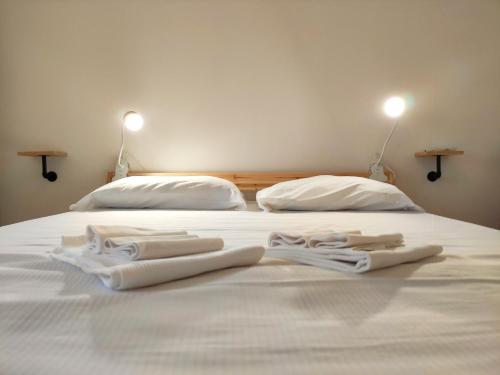un letto con due paia di asciugamani bianchi sopra di Airport Inn Preturo Affittacamere a San Vittorino