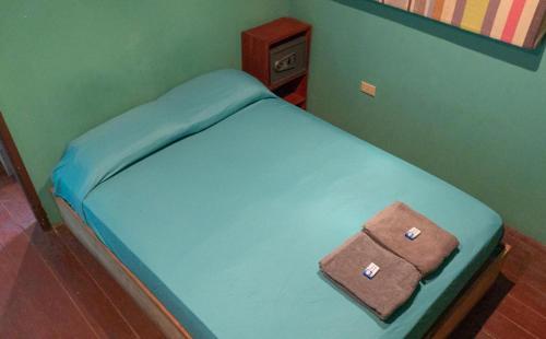 a small blue bed with a brown purse on it at Valerie Emanuel Apartments in Bocas del Toro