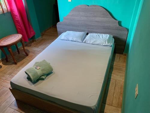 a small bed in a room with a chair at Valerie Emanuel Apartments in Bocas del Toro