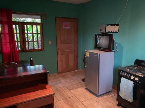a kitchen with a refrigerator and a tv on top of it at Valerie Emanuel Apartments in Bocas del Toro