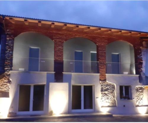ein großes Backsteingebäude mit blauen Türen und Fenstern in der Unterkunft Cascina la Demilana in Bibiana