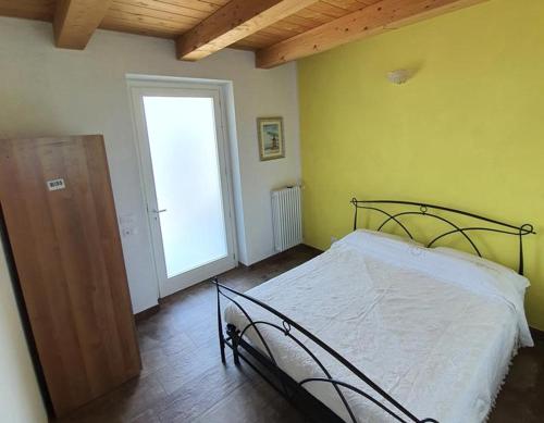 1 dormitorio con 1 cama en una habitación con ventana en Cascina la Demilana en Bibiana
