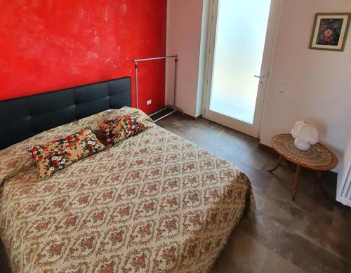 a bedroom with a bed and a red wall at Cascina la Demilana in Bibiana