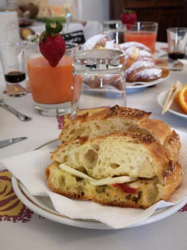 a table with a plate of food with a sandwich at Villa Ambra B&B in Noto