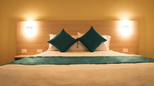 a bedroom with a large bed with green pillows at Balcones de la Quinta in Ríohacha