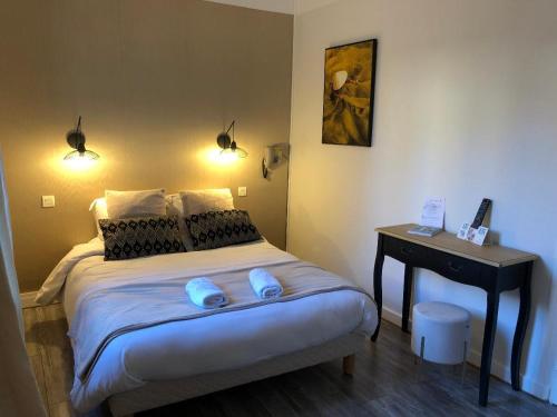 a bedroom with a bed with blue slippers on it at Hôtel Aux Vendanges de Bourgogne in Paray-le-Monial