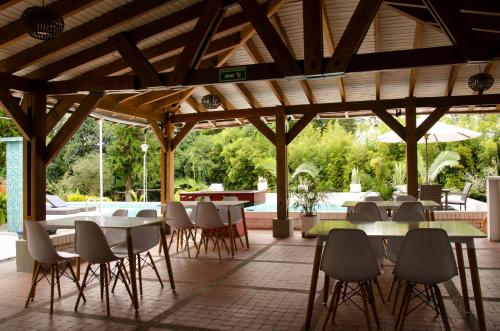 a restaurant with tables and chairs and a patio at Cotinga Hotel Spa in Pereira