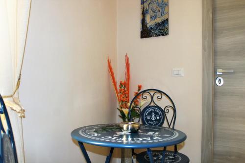 Una mesa azul con un jarrón de flores. en Essenza di Napoli, en Nápoles