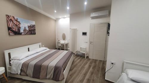 Un dormitorio pequeño con una cama y un espejo. en Garibaldi Rooms 29 - Piazza Marina a Palermo - In pieno Centro., en Palermo