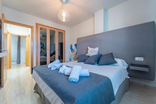Un dormitorio con una cama grande con almohadas azules. en Apartamentos Moon Dreams Almerimar, en Almerimar