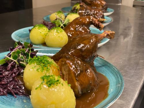 a plate of food with meat and potatoes on a table at HHotel Augsburg in Augsburg