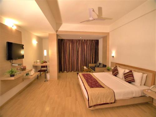 a hotel room with a bed and a television at IRA By Orchid Bhubaneswar in Bhubaneshwar