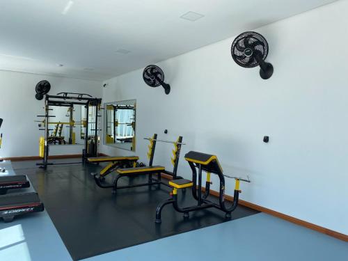 a gym with several chairs and a wall with weights at Executivos Hotel in Cruz Alta