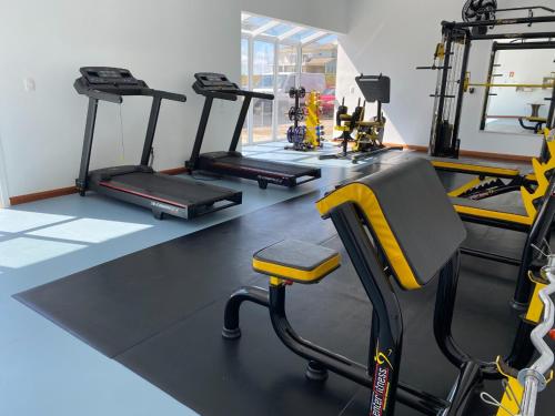 a gym with three treadmills and a treadmill at Executivos Hotel in Cruz Alta