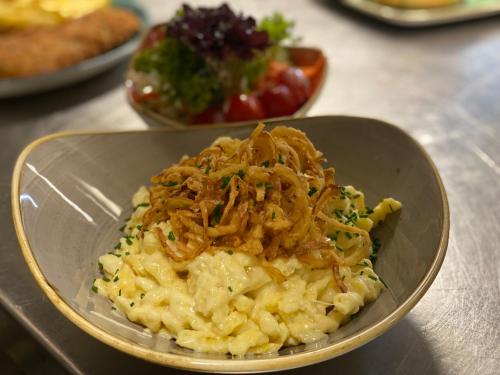 a bowl of macaroni and cheese with meat on it at HHotel Augsburg in Augsburg