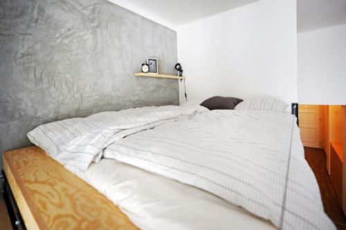 a bedroom with a bed with white sheets on it at Cosy Design Apartment in Brno