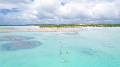 a group of people in the water at a beach at Ipioca Beach Resort Maceió in Maceió