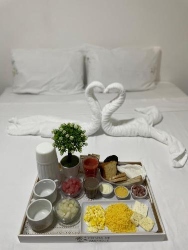 a tray with different types of food on a bed at Maragobeach Suits in Maragogi