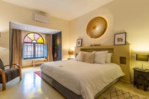 Un dormitorio con una gran cama blanca y una ventana en "LE 21", EXCLUSIVE DUPLEX 400m from Jemaa el Fna - JACUZZI - HAMMAM - NETFLIX - HIGH-SPEED WIFI, en Marrakech
