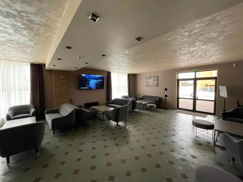 a waiting room with chairs and a flat screen tv at VILARHOTEL in Aizkraukle
