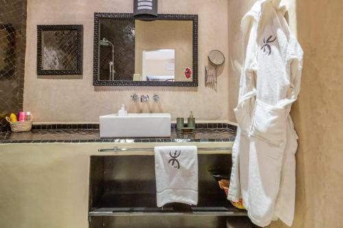 ein Bad mit einem Waschbecken und einem weißen Handtuch in der Unterkunft "LE 21", EXCLUSIVE LUXURY DUPLEX 400m FROM JEMAA EL FNA PLACE -HAMMAM-JACUZZI-KOUTOUBIA VIEW-ROOF TERRACE -SPEED WIFI in Marrakesch