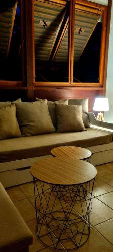 a living room with a couch and a table at Bungalow et Duplex de Island Bay in Bouillante