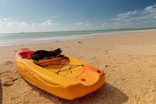 a yellow kayak is sitting on the beach at Ipioca Beach Resort Maceió in Maceió