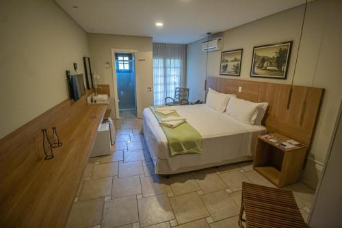 a bedroom with a bed and a television in it at WINNER BEACH HOTEL in Juréia