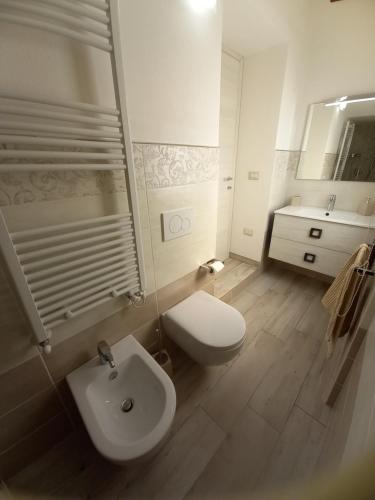 ein weißes Bad mit einem WC und einem Waschbecken in der Unterkunft Titina's House in Tertenìa