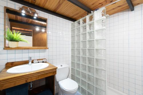 ein Badezimmer mit einem WC, einem Waschbecken und einem Spiegel in der Unterkunft La Casita in El Médano