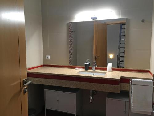 a bathroom with a sink and a large mirror at Sleep In Bucelas in Bucelas