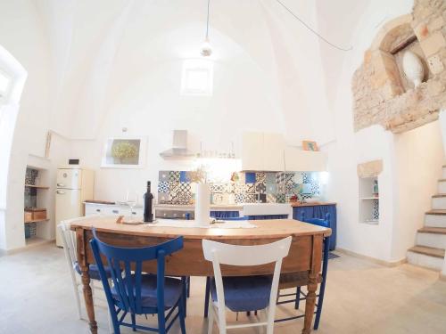 a kitchen with a wooden table and blue chairs at Antica Dimora Salentina in Leverano