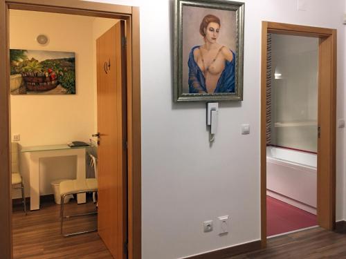 a painting of a woman on a wall next to a door at Sleep In Bucelas in Bucelas