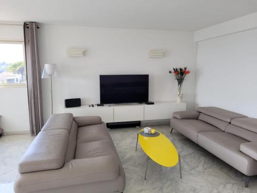 uma sala de estar com um sofá e uma mesa amarela em CANNES Superbe appartement vue mer panoramique em Cannes