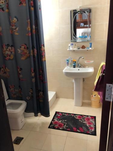 y baño con lavabo, aseo y cortina de ducha. en Red Sea Tiba plaza Apartment, en Hurghada