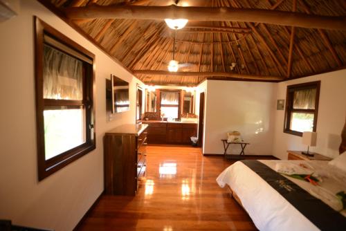 a bedroom with a bed and a kitchen in a room at El Ben Cabañas in Caye Caulker