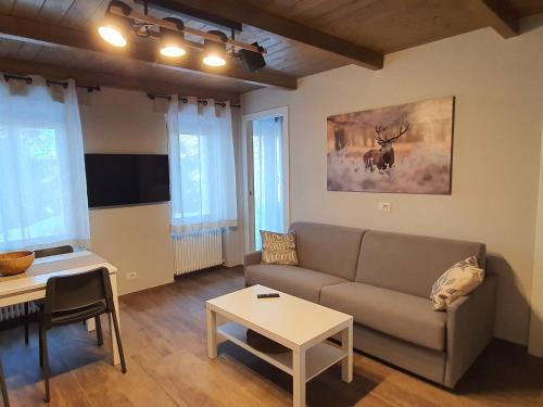 uma sala de estar com um sofá e uma mesa em Moda Apartments 01 em Sestriere