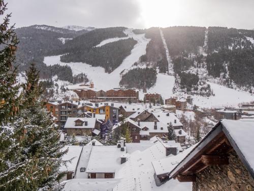 a town covered in snow with mountains in the background at Pleta del Tarter Lodge in El Tarter