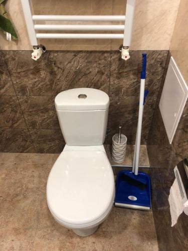 a white toilet in a bathroom with a mop at Ashtarak-1 Modern Apartment in Ashtarak