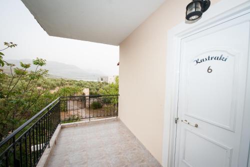 a room with a white door and a balcony at Kastraki Studios in Stoupa