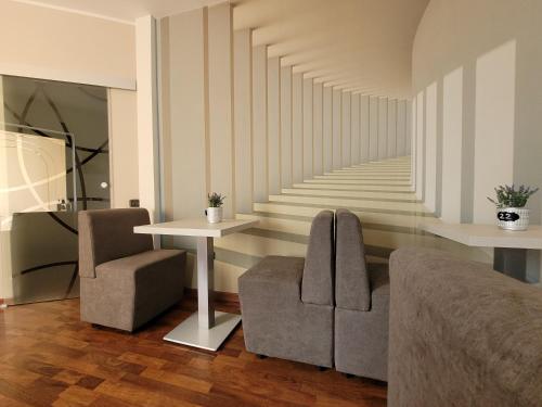 een woonkamer met 2 stoelen, een tafel en een trap bij Bed & Breakfast ospiti a corte in Giffoni Valle Piana