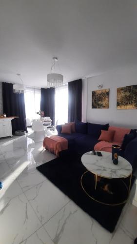 un salon avec un canapé et une table dans l'établissement Apartament Słoneczny, à Dziwnówek