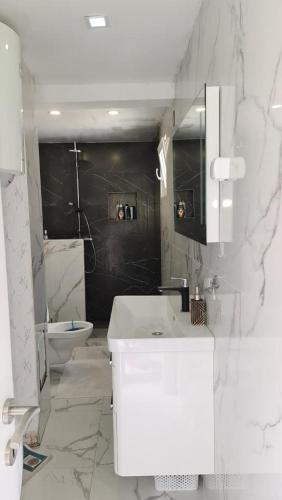 a white bathroom with a sink and a toilet at Sea side apartment in Kotor