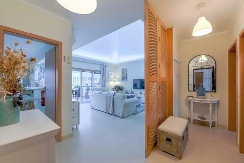 a living room with a couch and a table at Penthouse Dali - Cabanas Beach Club in Cabanas de Tavira