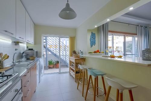 a kitchen with a counter and some stools in it at Penthouse Dali - Cabanas Beach Club in Cabanas de Tavira
