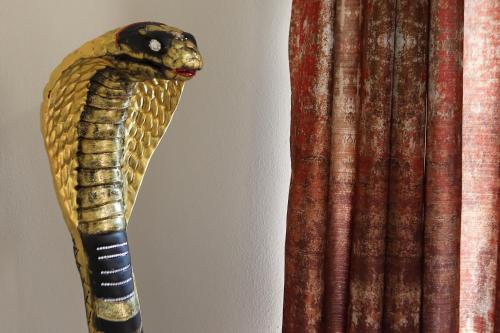 a carved snake head sticking out of a curtain at B&B Bellavista Exclusive in zona centrale con piscina riscaldata e Jacuzzi vista lago LA COLAZIONE viene servita in una pasticceria rinomata ed esclusiva esterna alla struttura in Desenzano del Garda