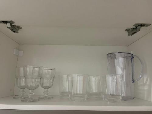 a row of empty glasses sitting on a shelf at Flat JK 202 in Juazeiro do Norte